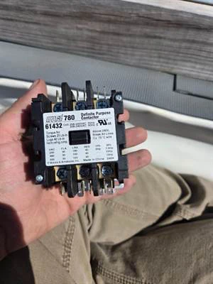 Replacement contactor in the technician's hand before install